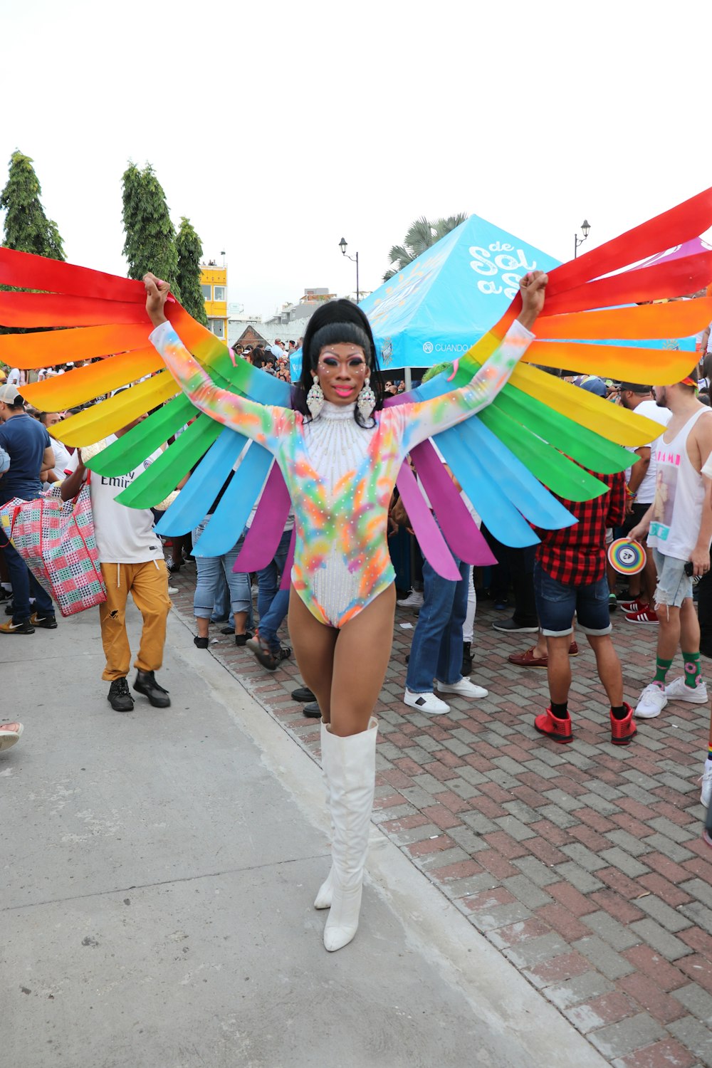 uma mulher em um traje colorido está segurando uma pipa