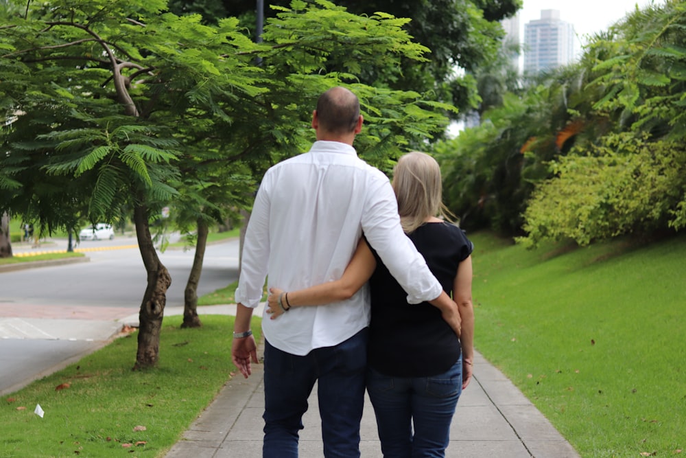 a man and a woman walking down a sidewalk