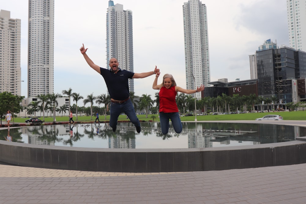 a man and a woman standing in front of a fountain