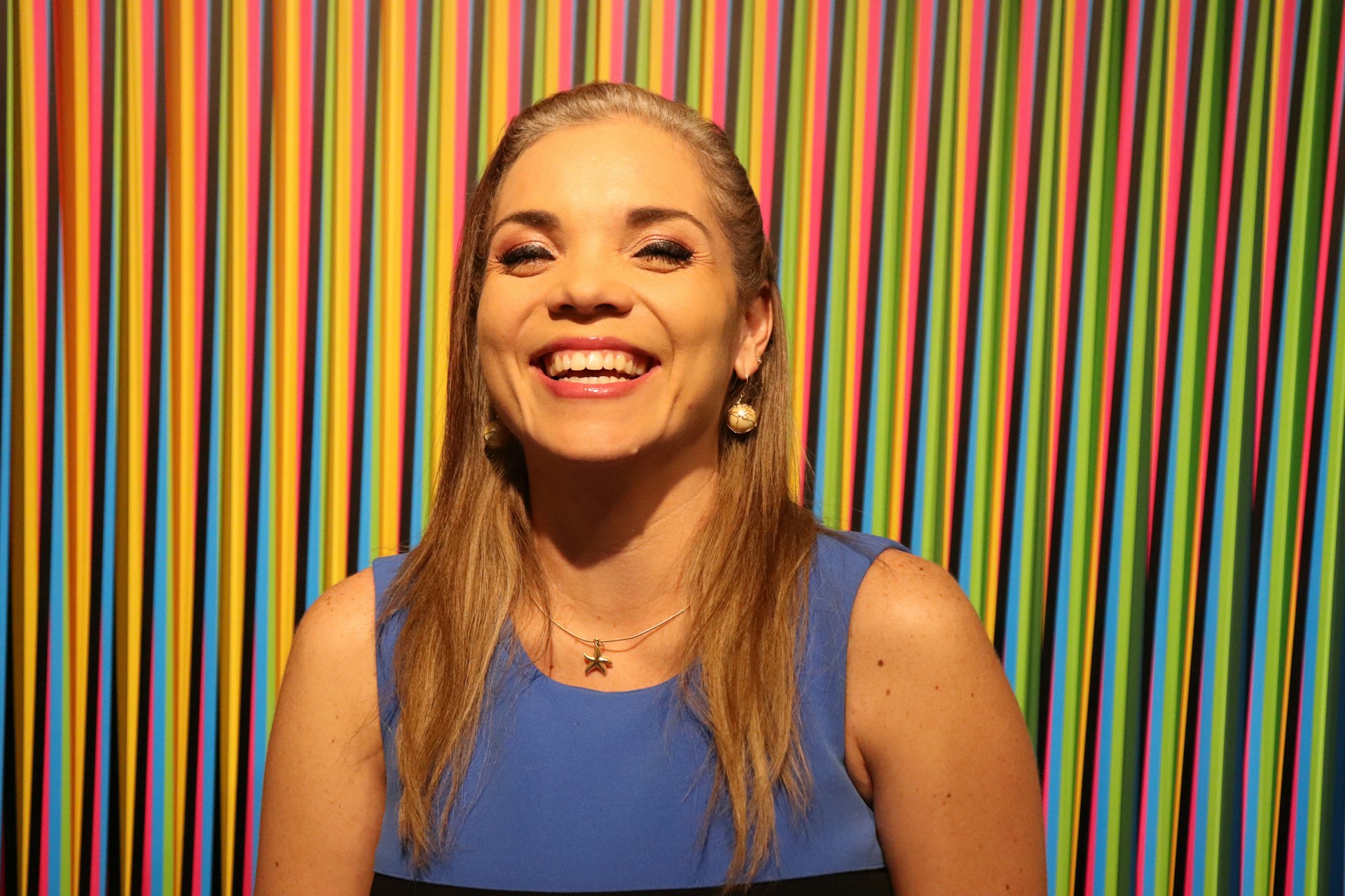a woman standing in front of a colorful wall