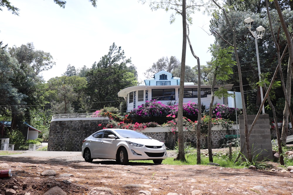 a white car parked in front of a house