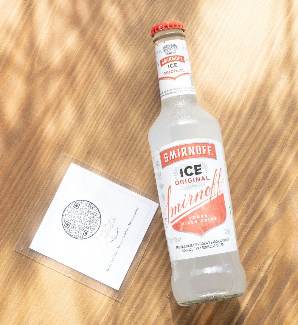 a bottle of ice water sitting on top of a wooden table