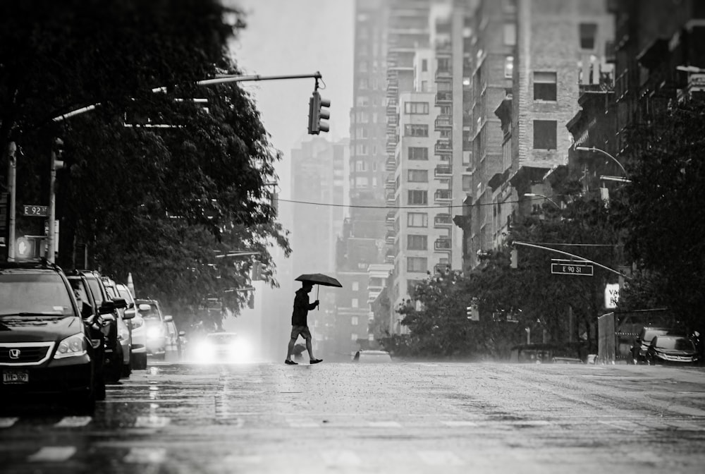 a person with an umbrella crossing the street