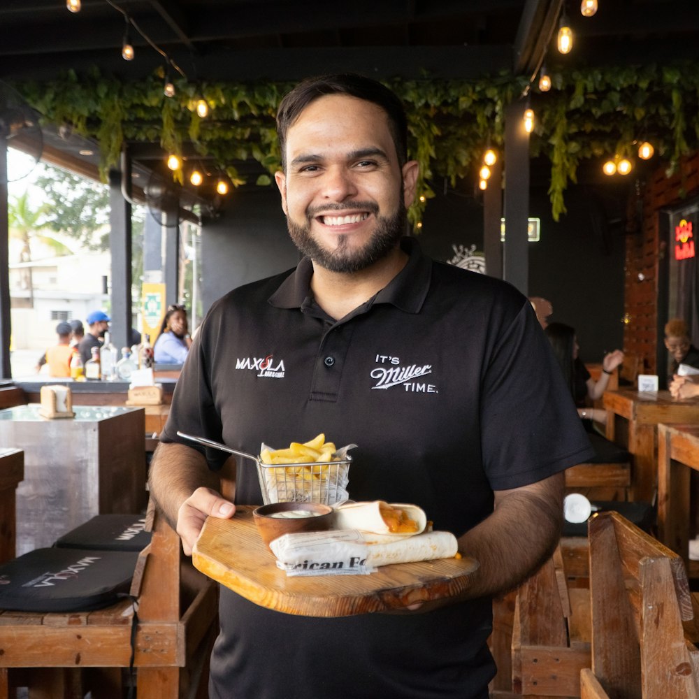 a man holding a tray of food in a restaurant