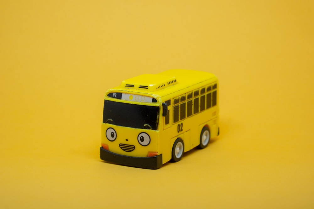 Un bus jouet jaune sur fond jaune
