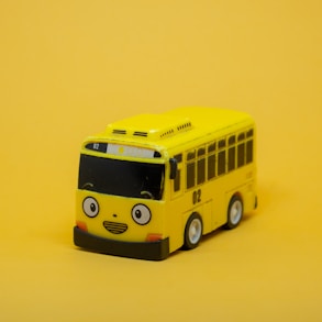 a yellow toy bus on a yellow background