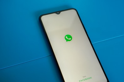 a white and black phone with a green whatsapp sticker on it