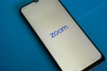 a close up of a cell phone with the zoom logo on it