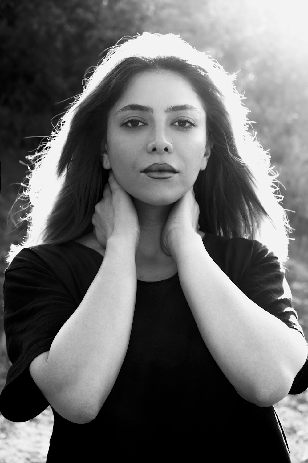 a black and white photo of a woman with her hands on her chest