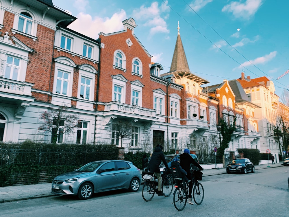 a couple of people riding bikes down a street