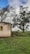a small building sitting on top of a lush green field