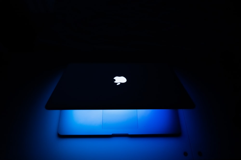 an apple computer lit up in the dark