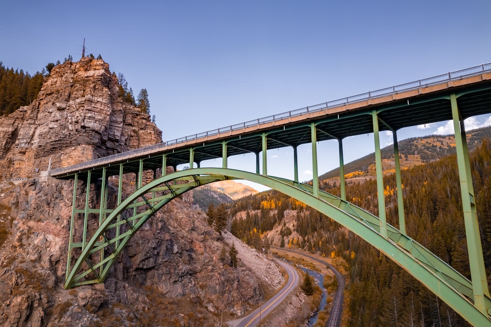 un puente sobre una montaña con una carretera que pasa por debajo de ella