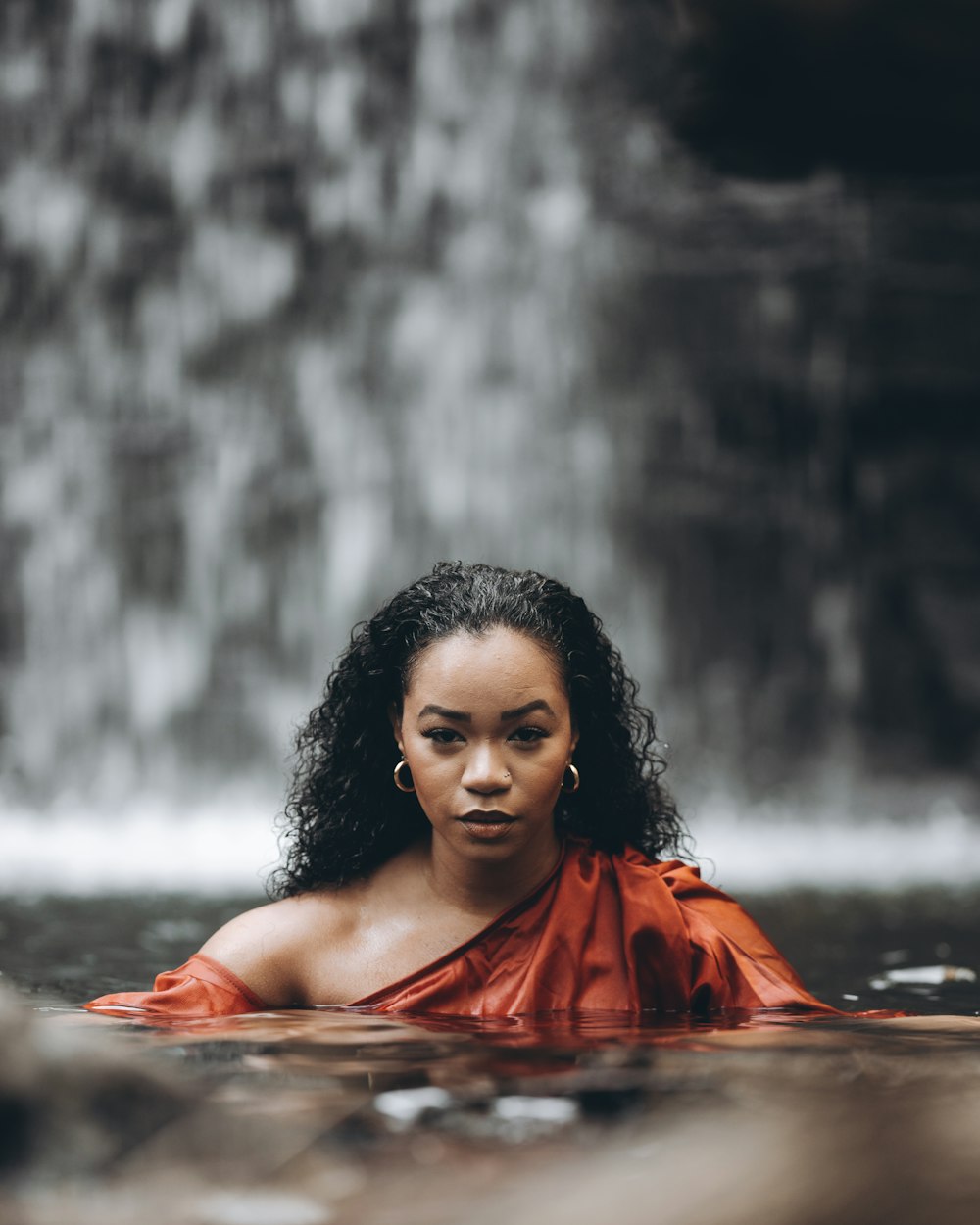 Una mujer con un vestido rojo está en el agua