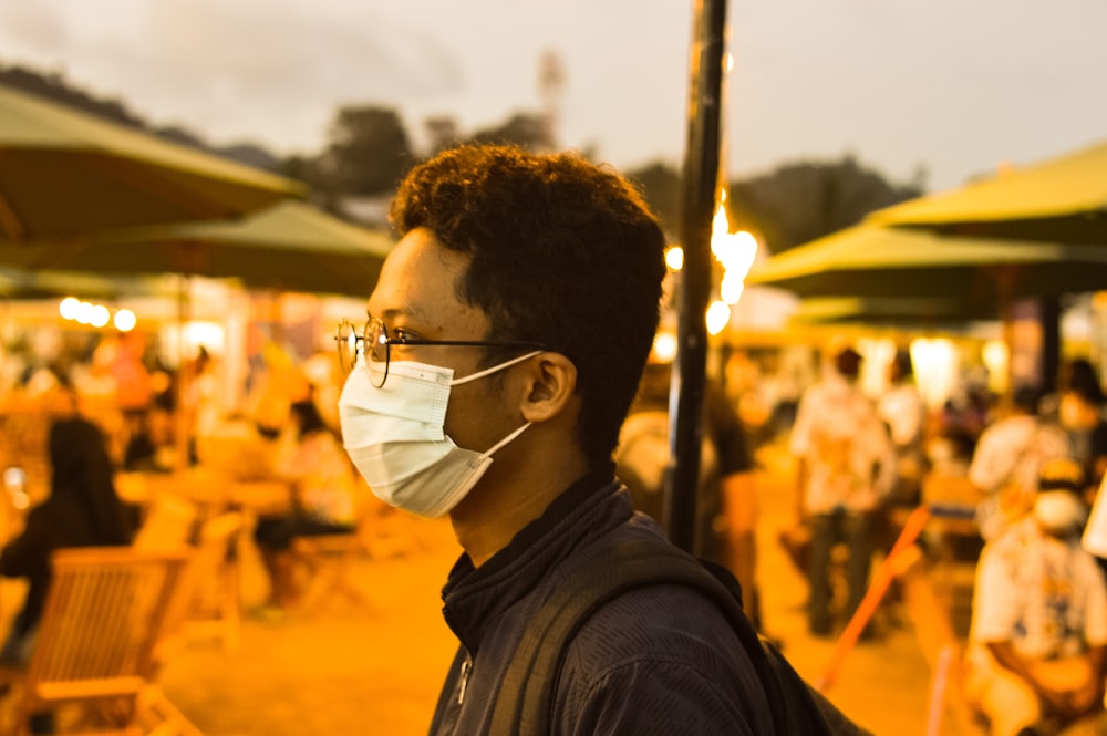 a man wearing a face mask in front of a crowd of people