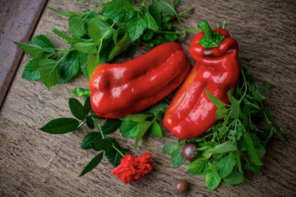 a couple of red peppers sitting on top of a wooden table