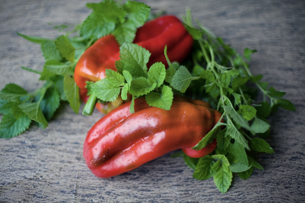 a group of red peppers with green leaves