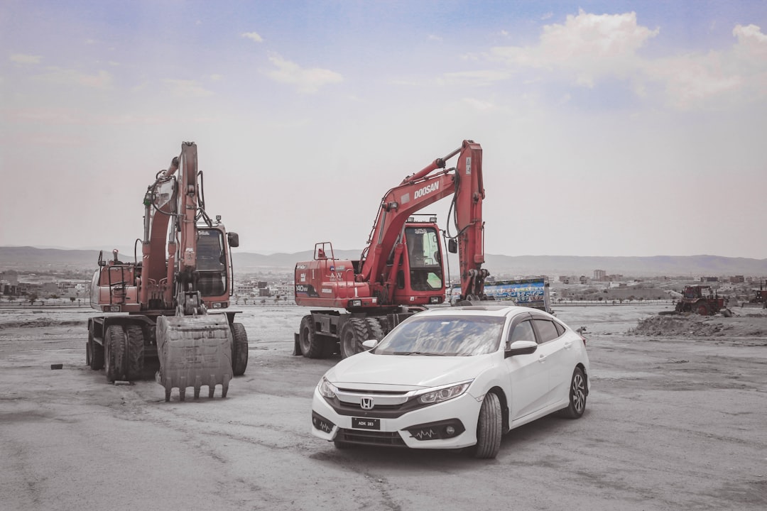 a white car parked in a lot next to a tractor, All Hail to the King <3