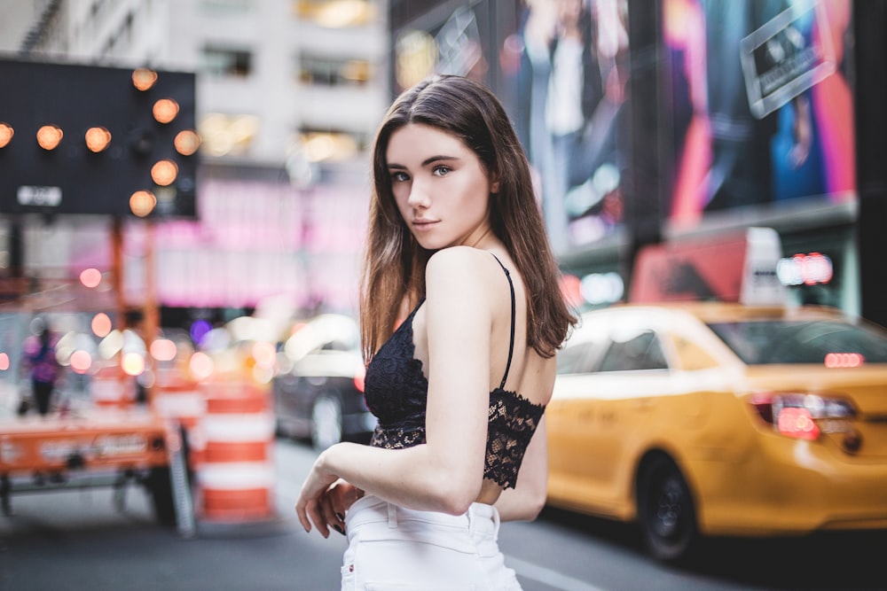 a woman in a black top and white skirt on a city street