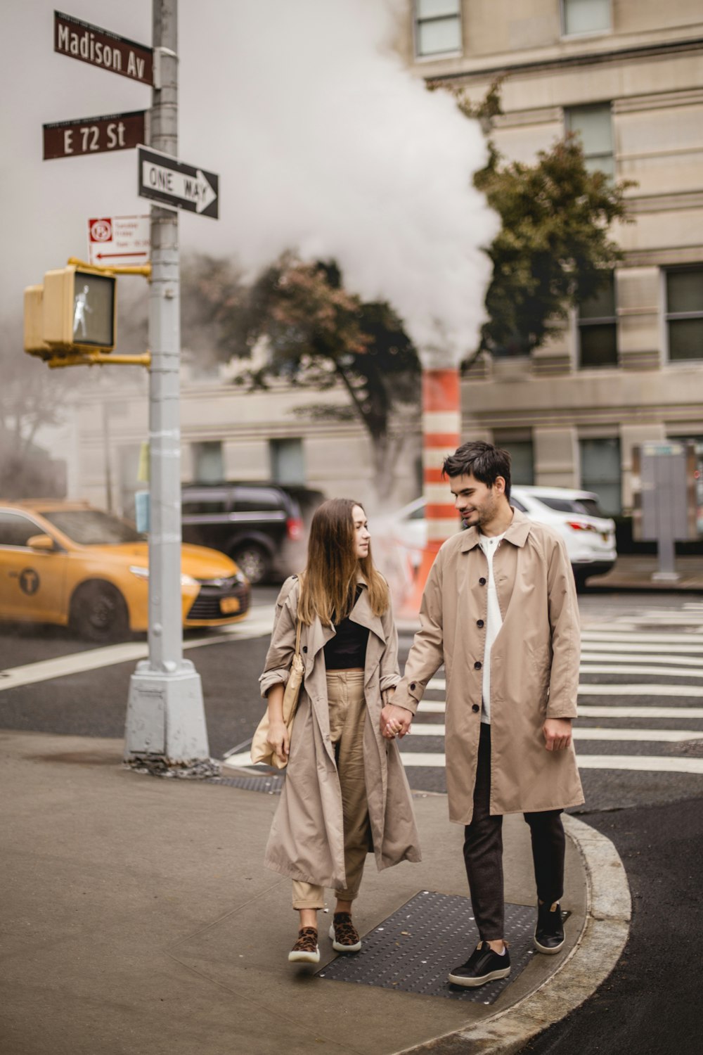 a man and a woman walking down a street holding hands