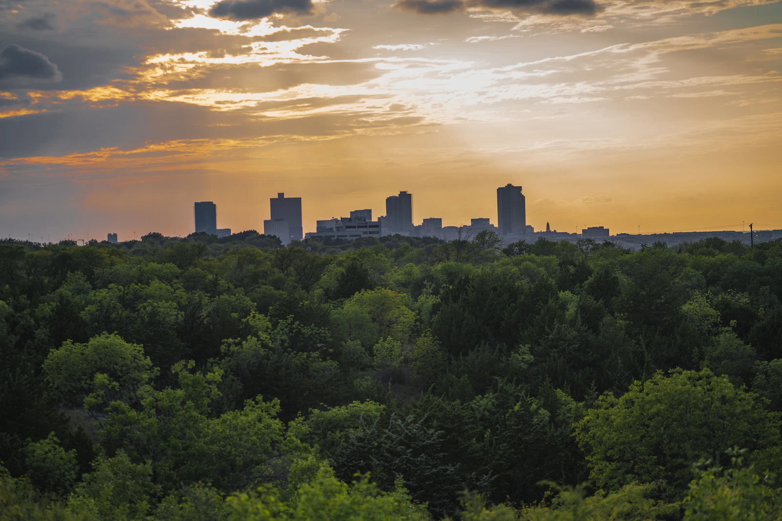 Fort Worth skyline at sunset with warm restrained tones and open sky.