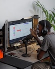a man wearing headphones sitting in front of a computer