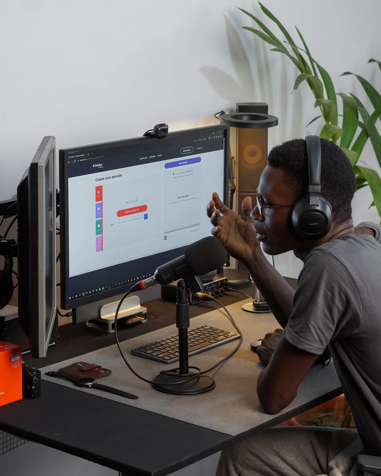 Instructor with headphones recording audio in front of a computer