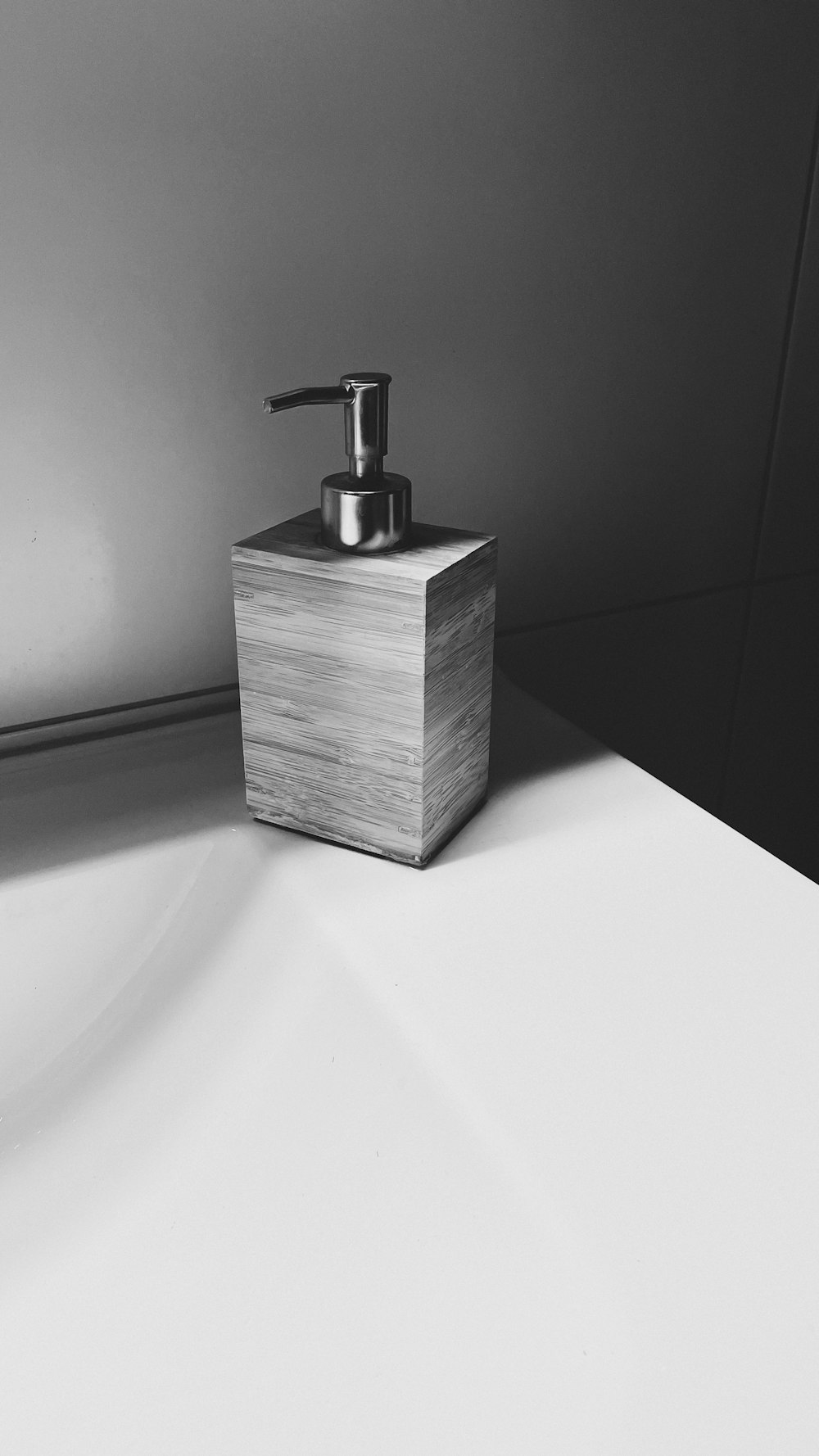 a soap dispenser sitting on top of a white counter