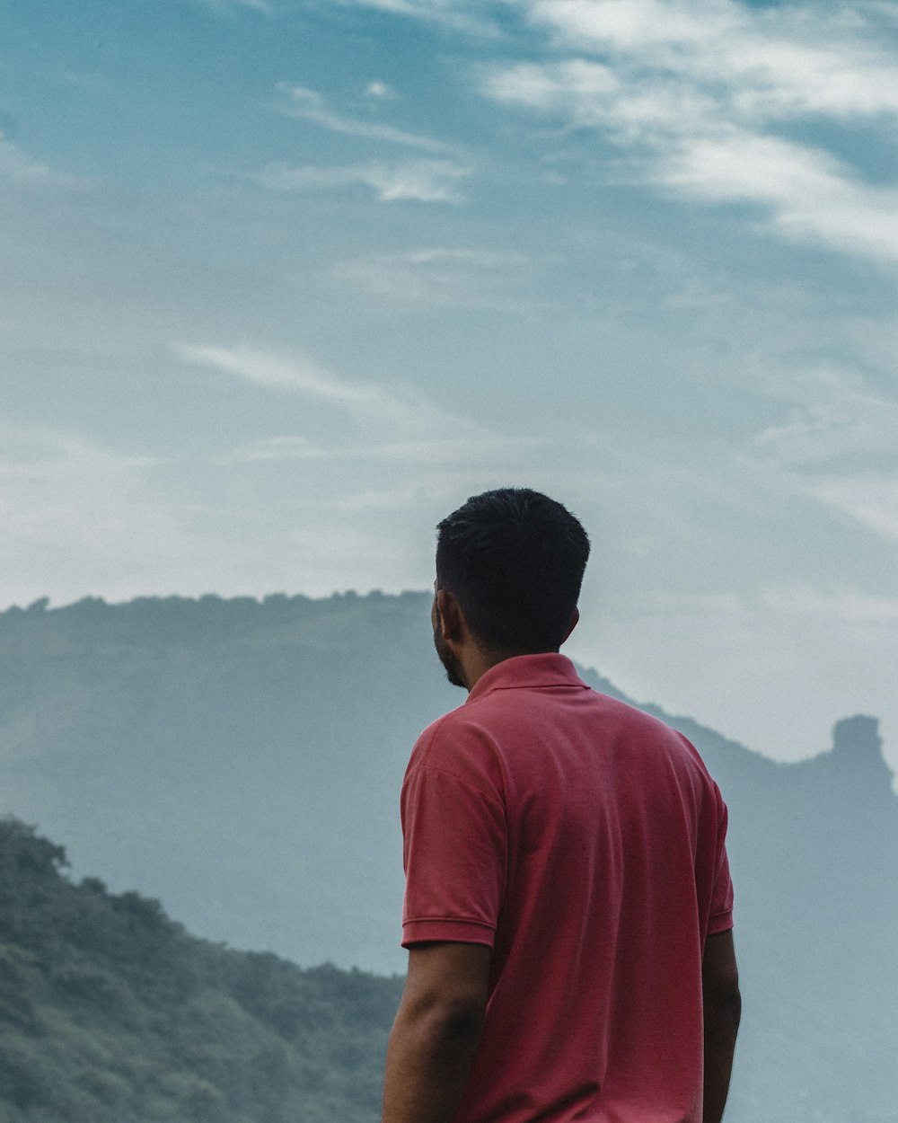 a man standing on top of a lush green hillside