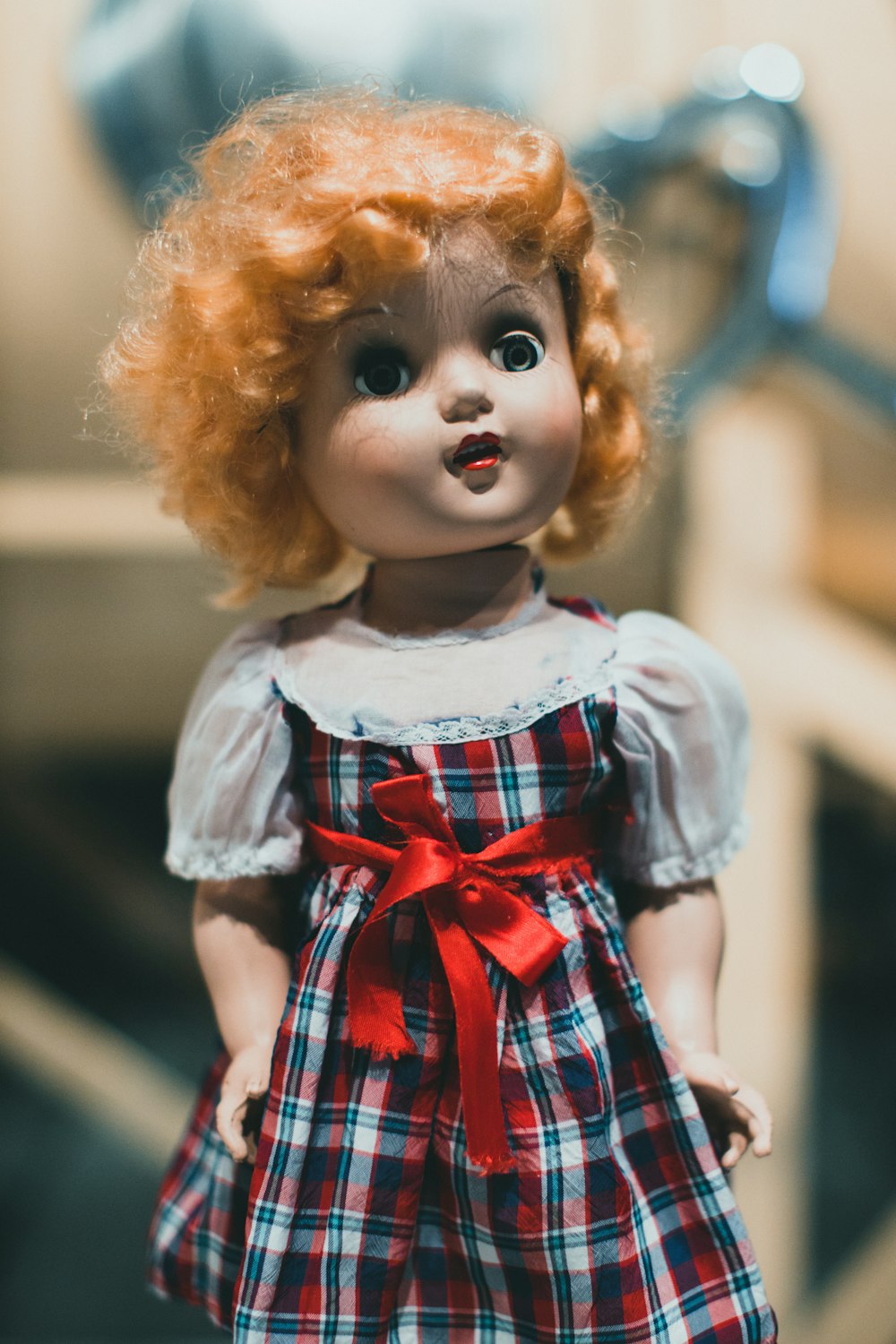 a close up of a doll with red hair