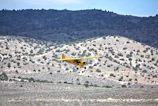 Aerial shot of a small private plane flying over the rugged Santa Fe landscape.