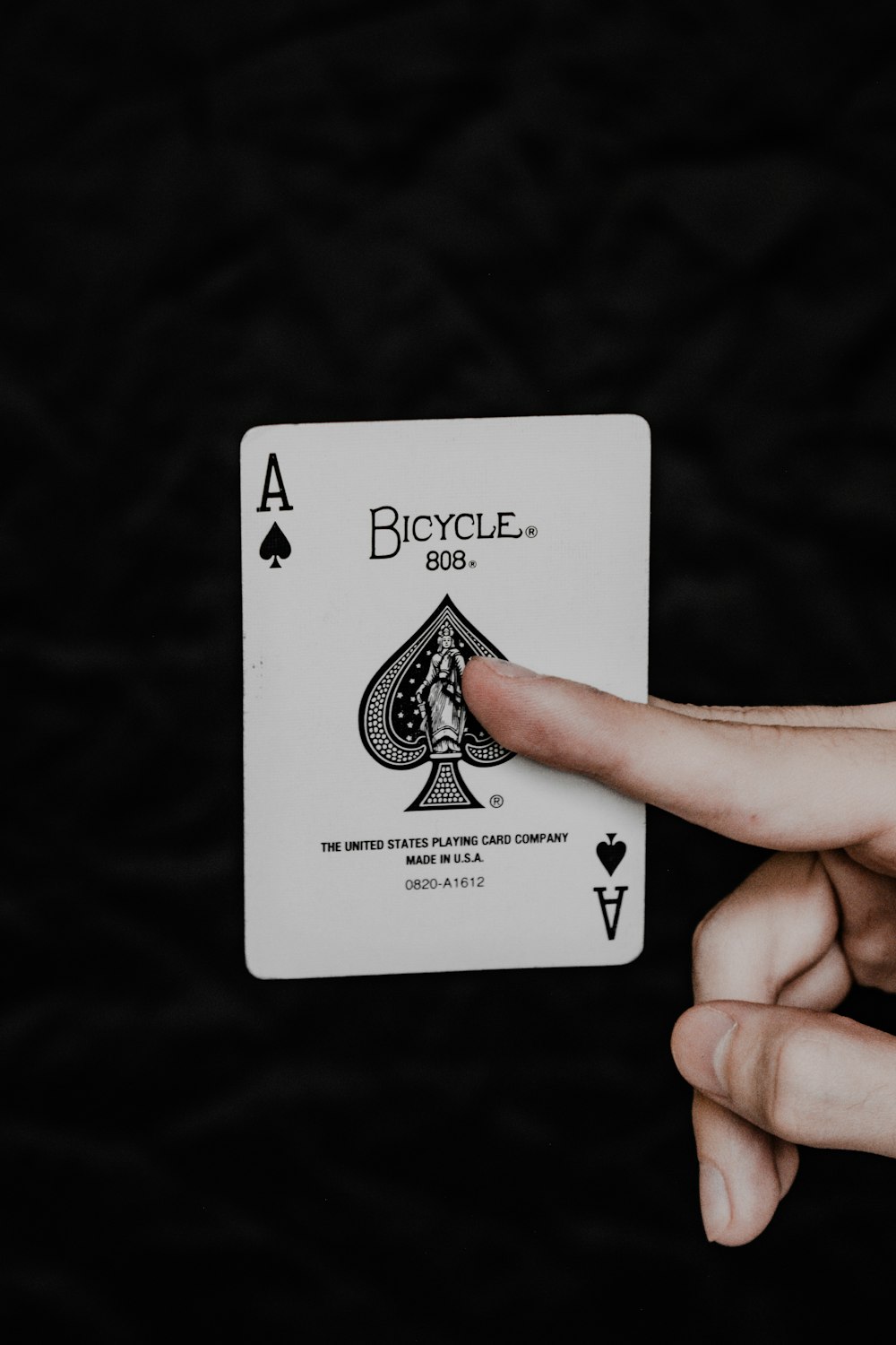 a person holding a playing card in their hand