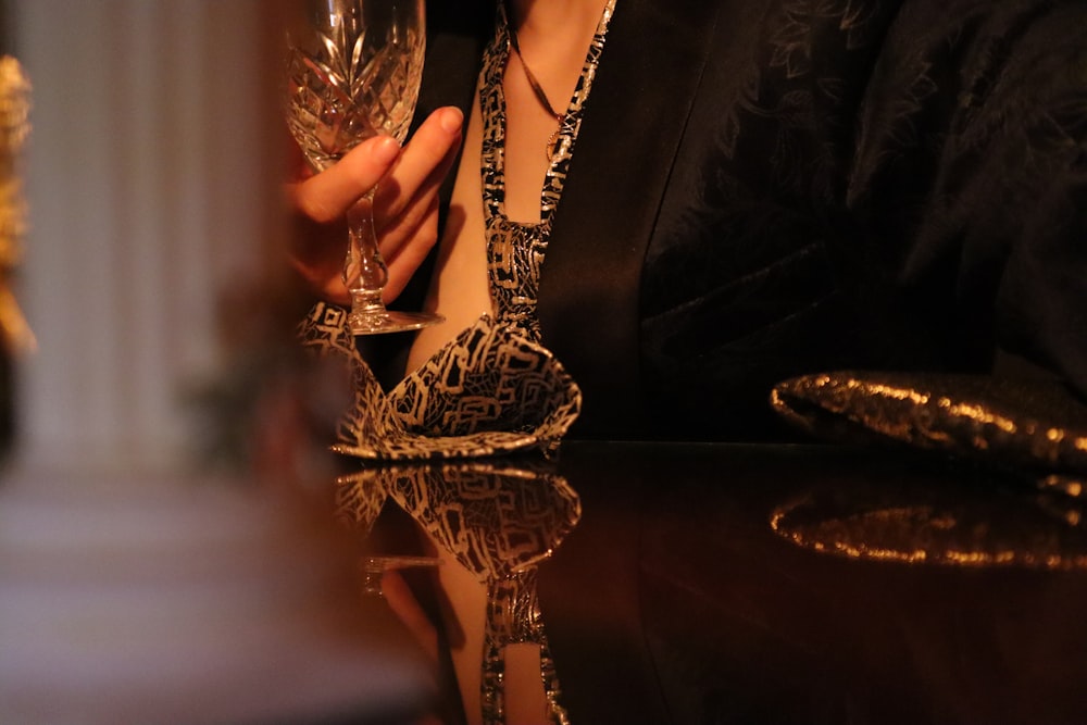a close up of a person holding a wine glass