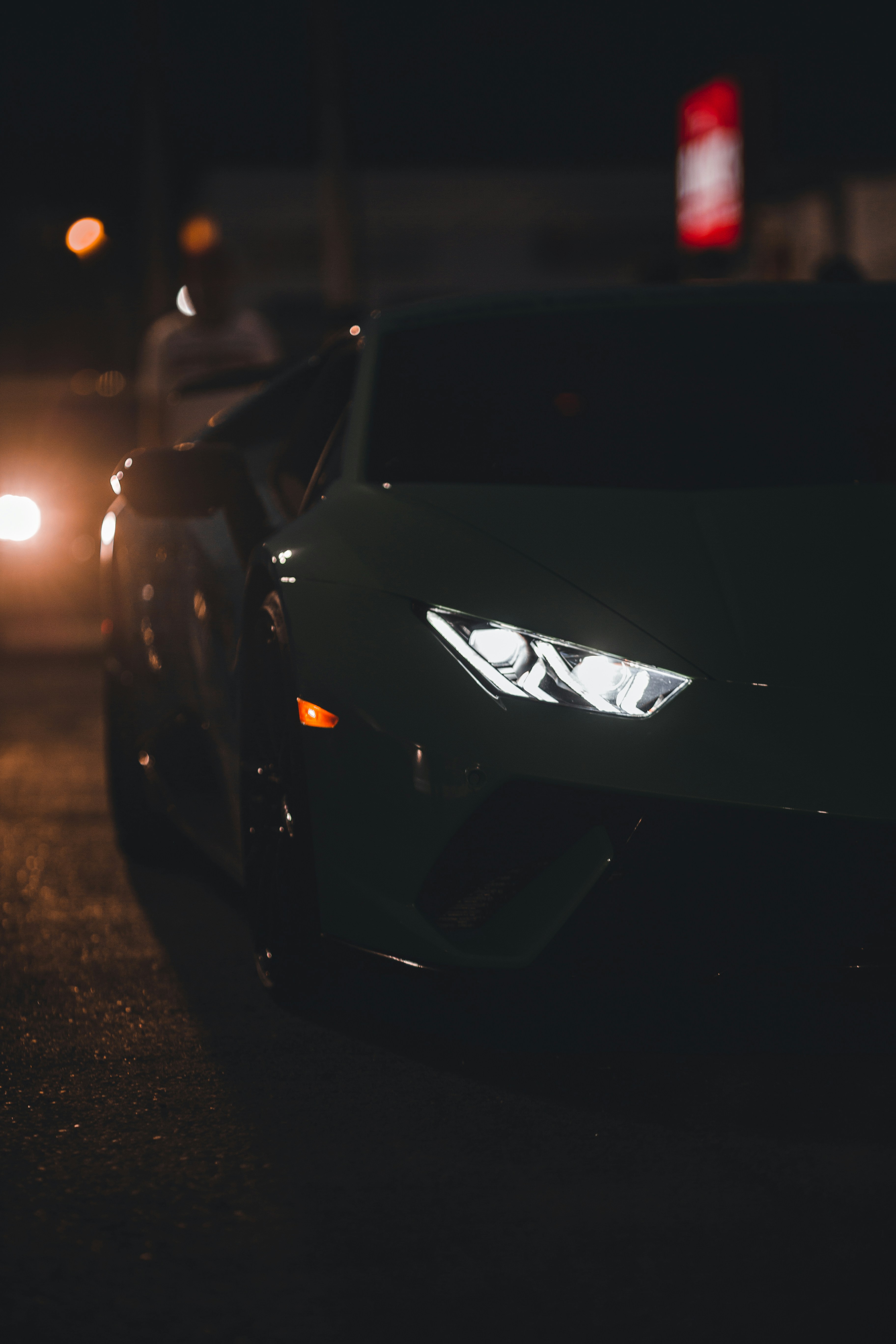 Un auto deportivo negro conduciendo por una calle por la noche foto –  Imagen de Coche gratuita en Unsplash, image size:3000x4500