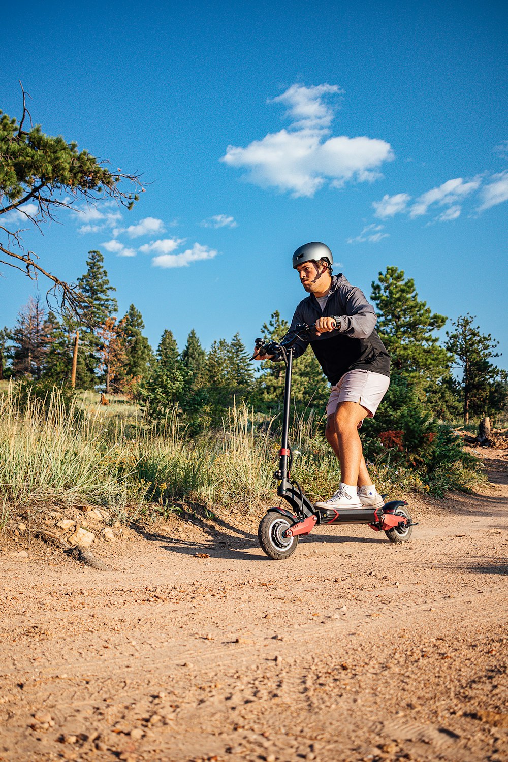 a man riding a scooter down a dirt road