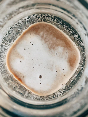 Close-up of a jar filled with thick, golden grass-fed beef bone broth showing its gelatinous texture.