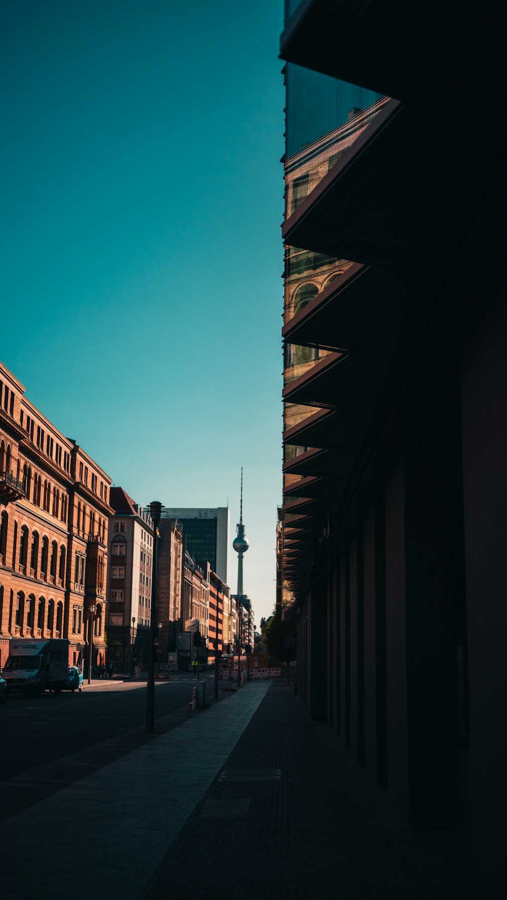 a city street lined with tall buildings under a blue sky