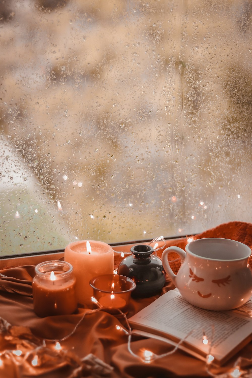 Una taza de café encima de una mesa junto a una ventana