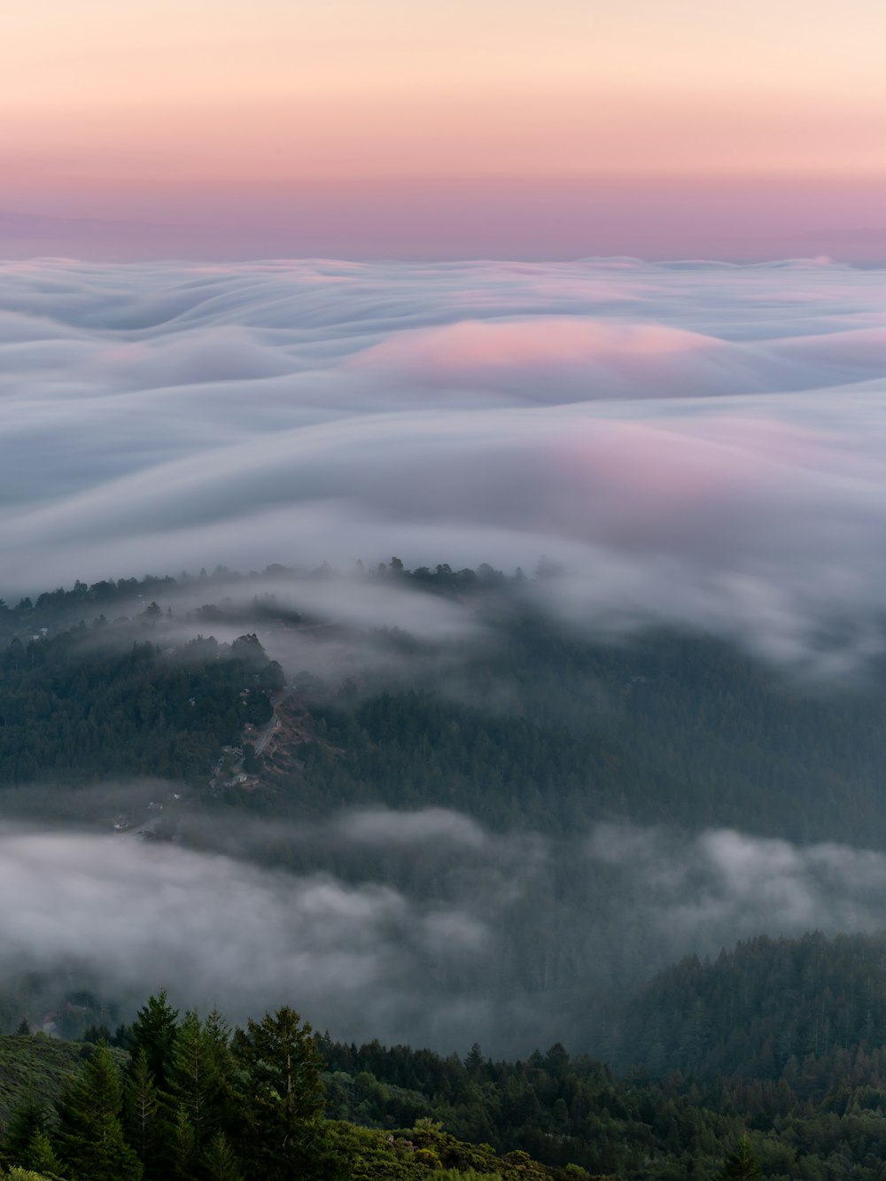 a view of a mountain covered in clouds