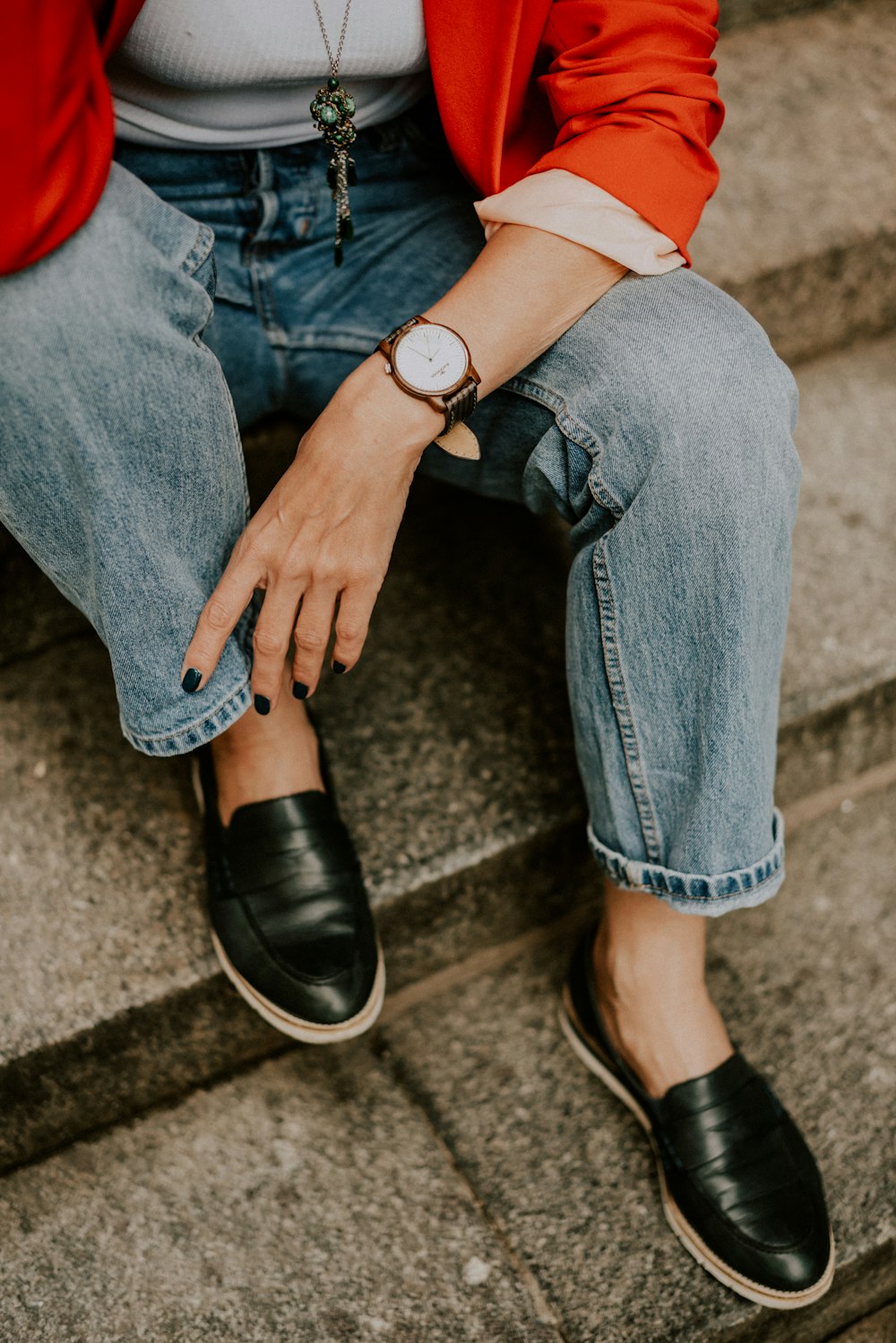 a woman sitting on steps wearing a watch