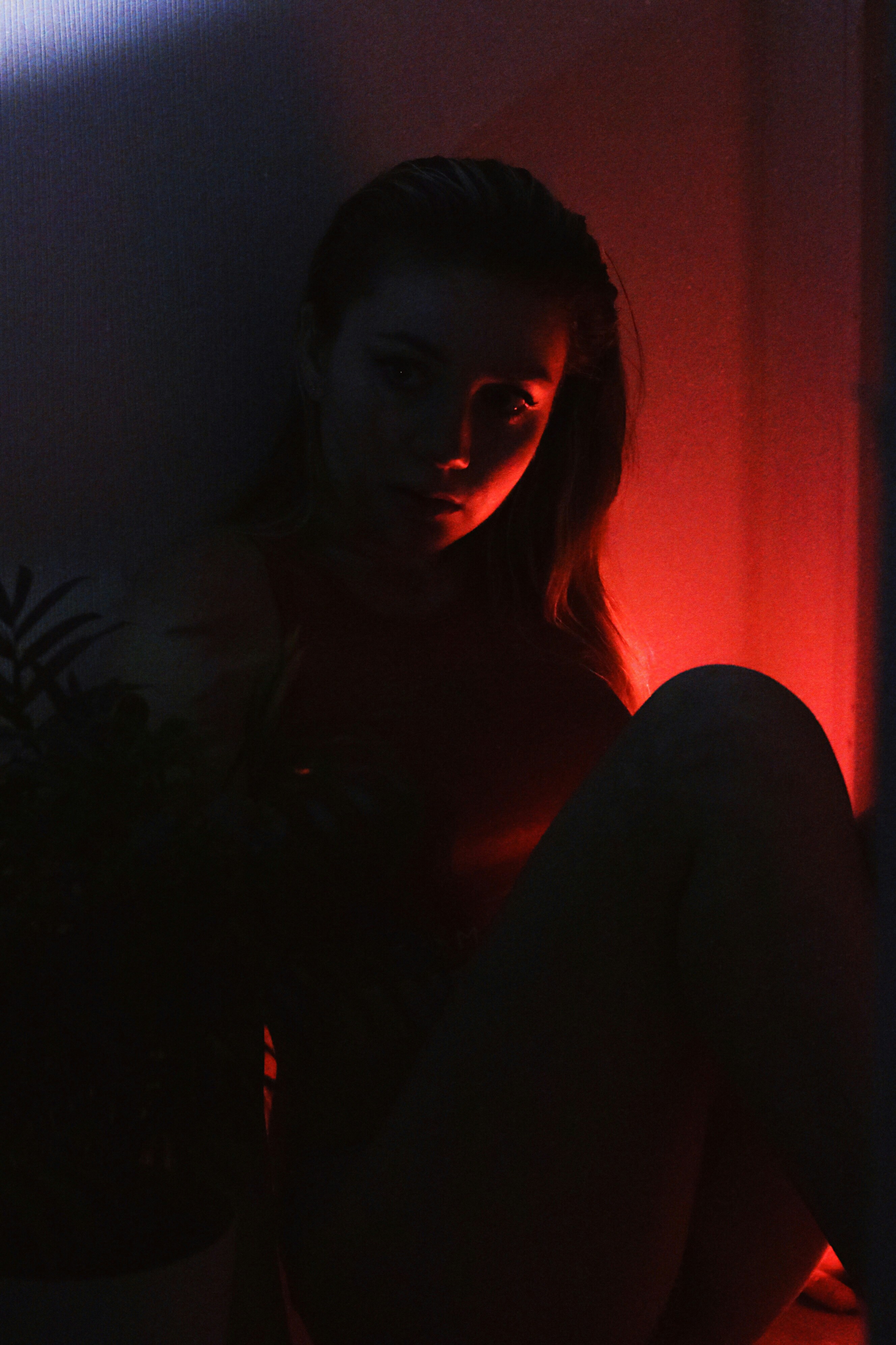 Artist Mara Soleil with deep red moody lighting