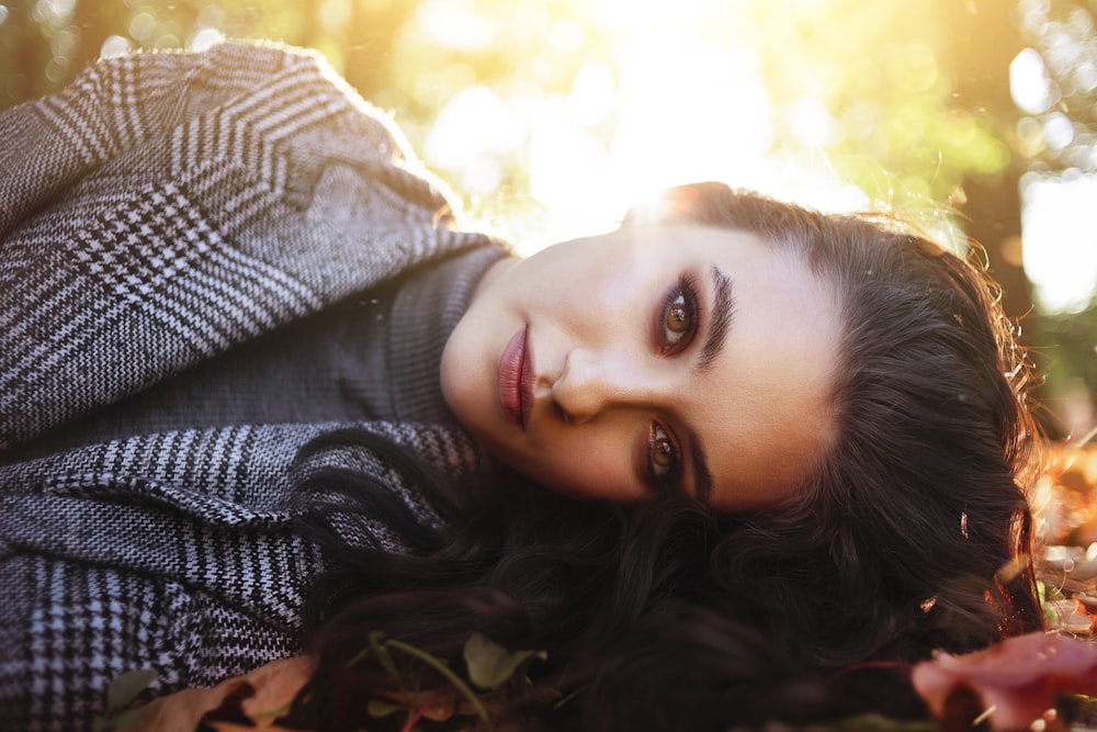 a woman laying on the ground in the leaves