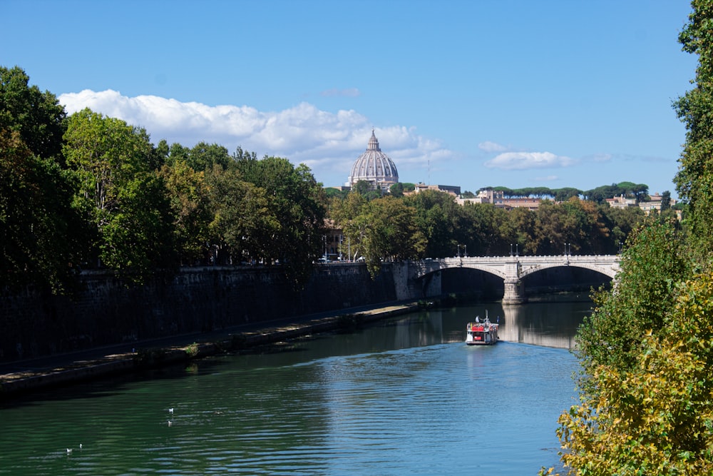 a boat traveling down a river next to a bridge