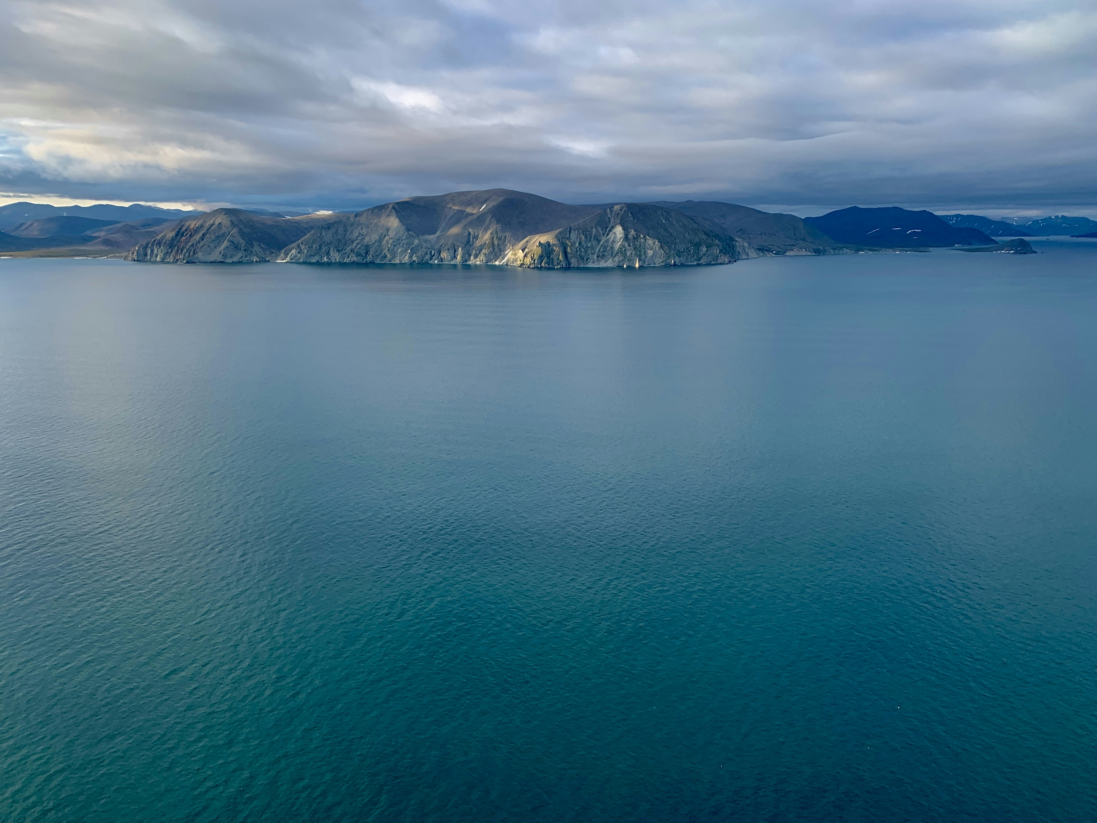 a large body of water with mountains in the background