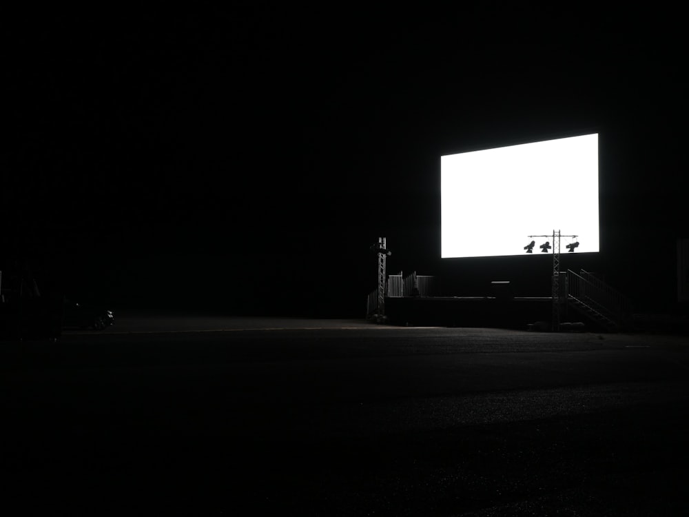 a dark room with a large screen in the middle of it