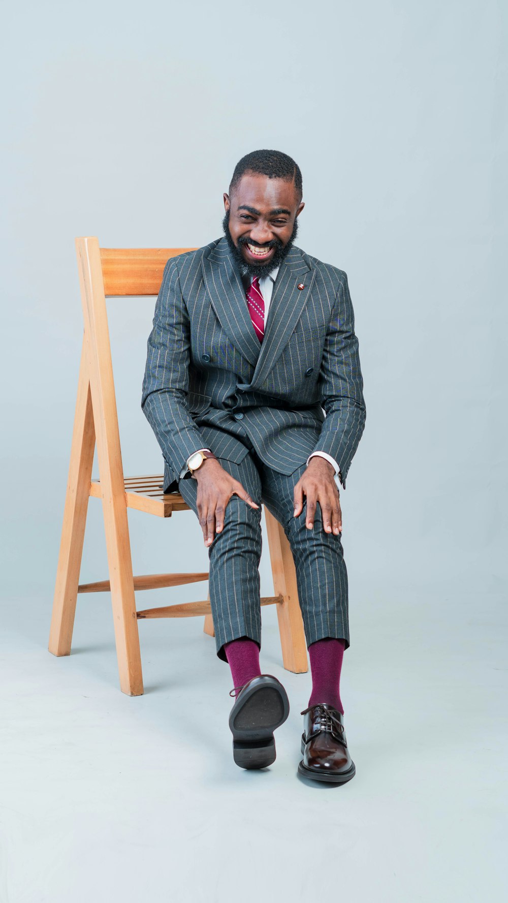 a man in a suit and tie sitting on a chair