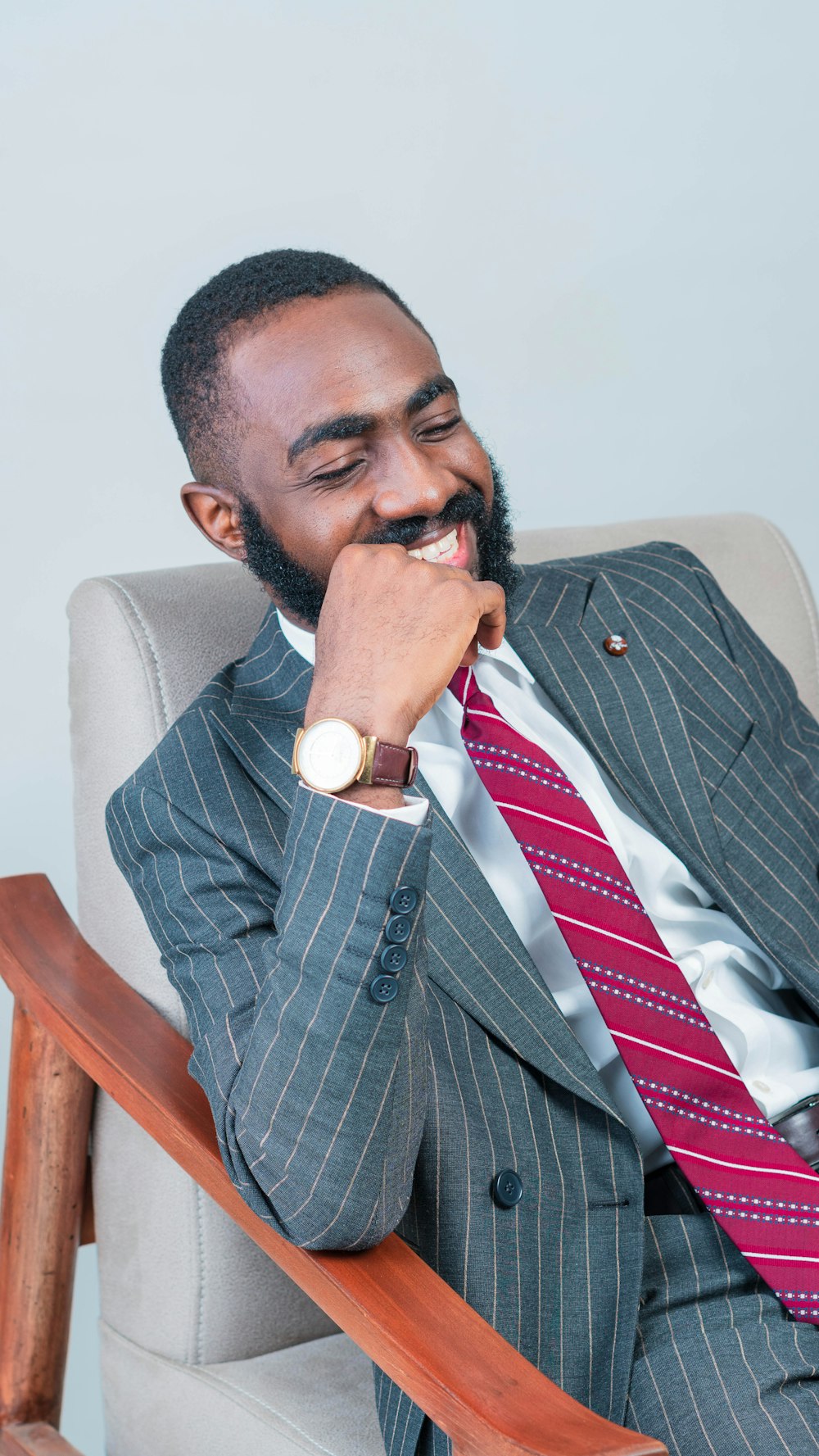 a man in a suit and tie sitting in a chair