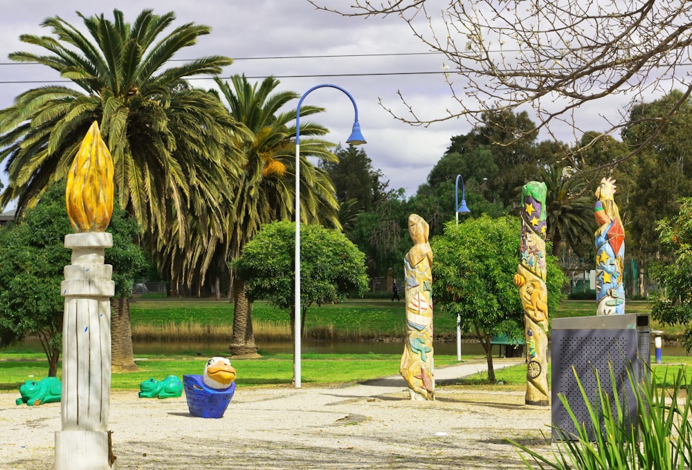 a park with palm trees and sculptures in the background