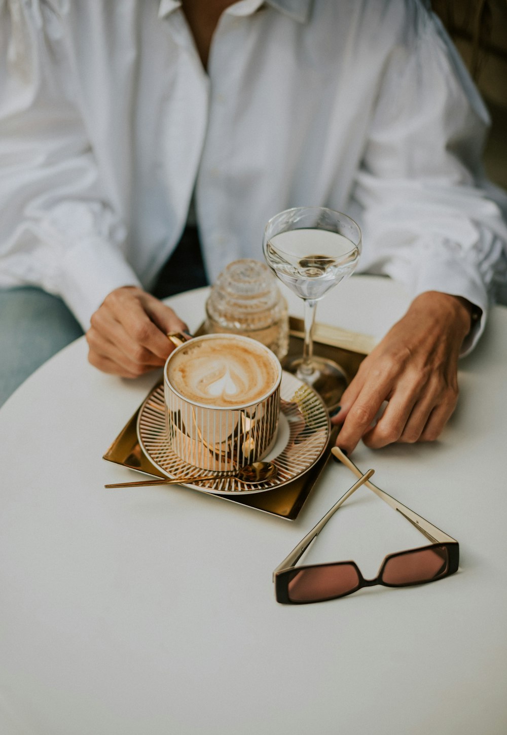 a person sitting at a table with a cup of coffee