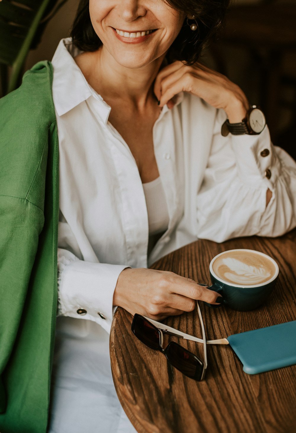 Une femme assise à une table avec une tasse de café